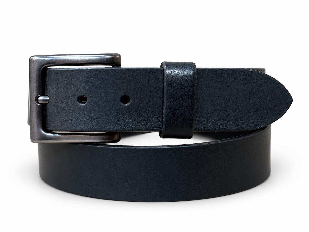 Full Grain Black Latigo Leather Belt coiled with a gunmetal buckle against a white background.