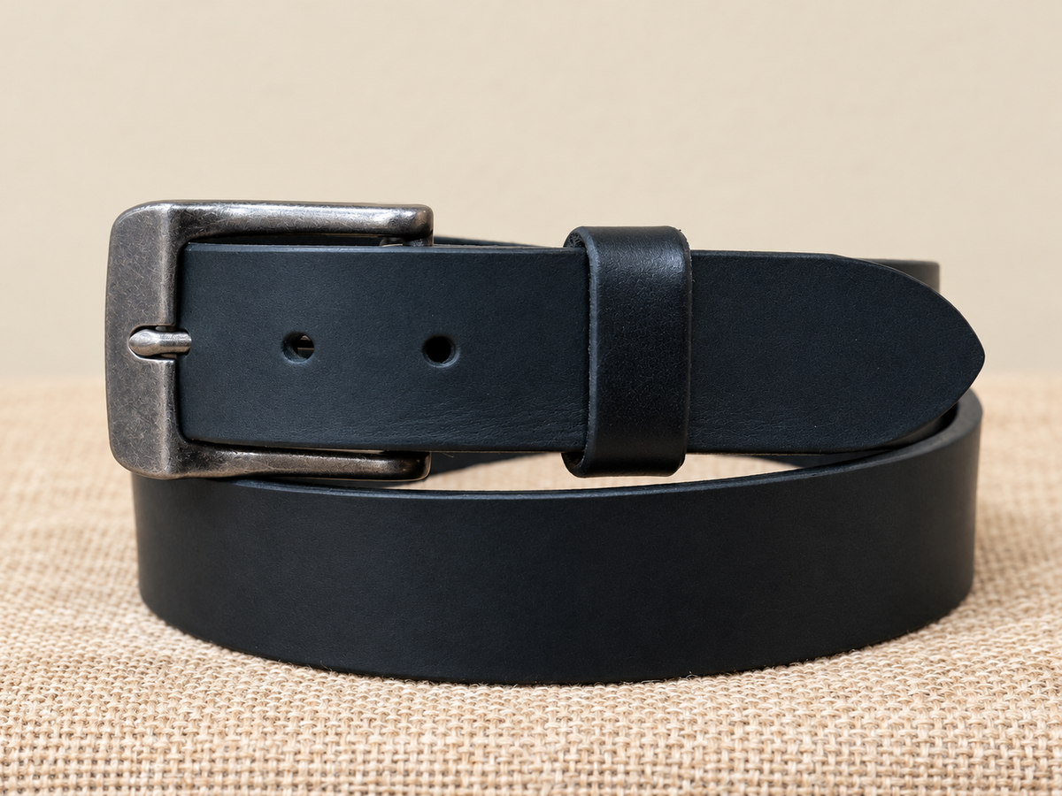 Full Grain Black Latigo Leather Belt close-up with an antiqued metal buckle on burlap.
