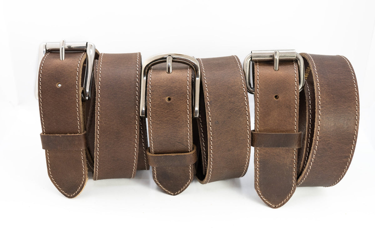 Three brown leather belts with silver buckles on a white background
