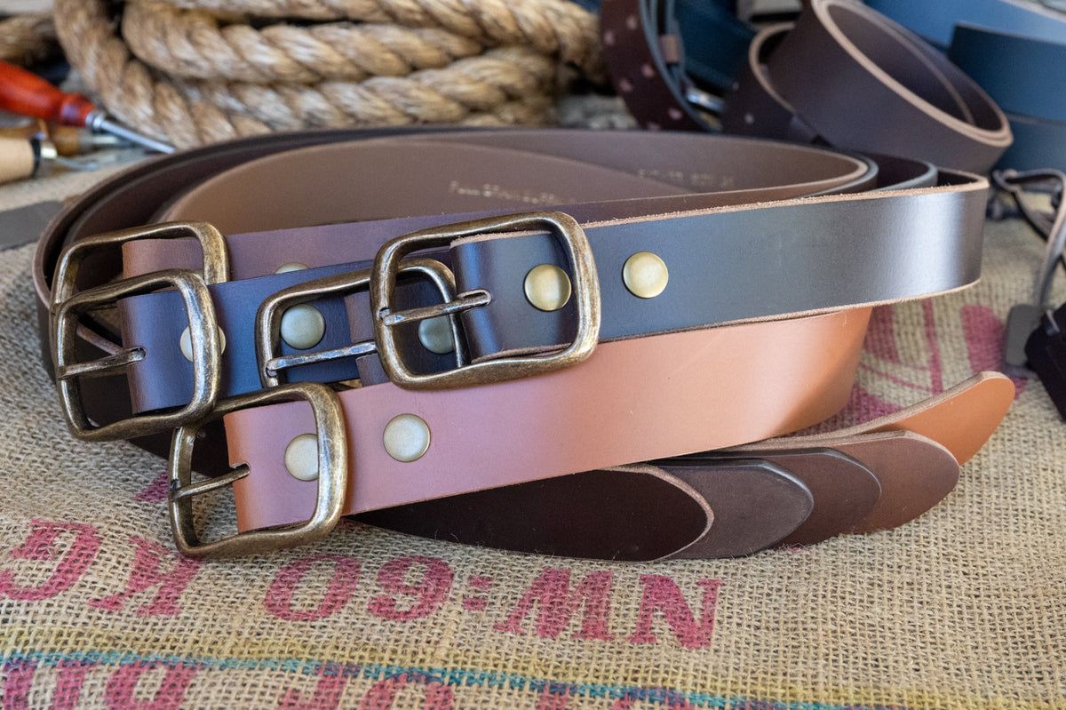 Leather belt with brass buckles on a textured fabric background