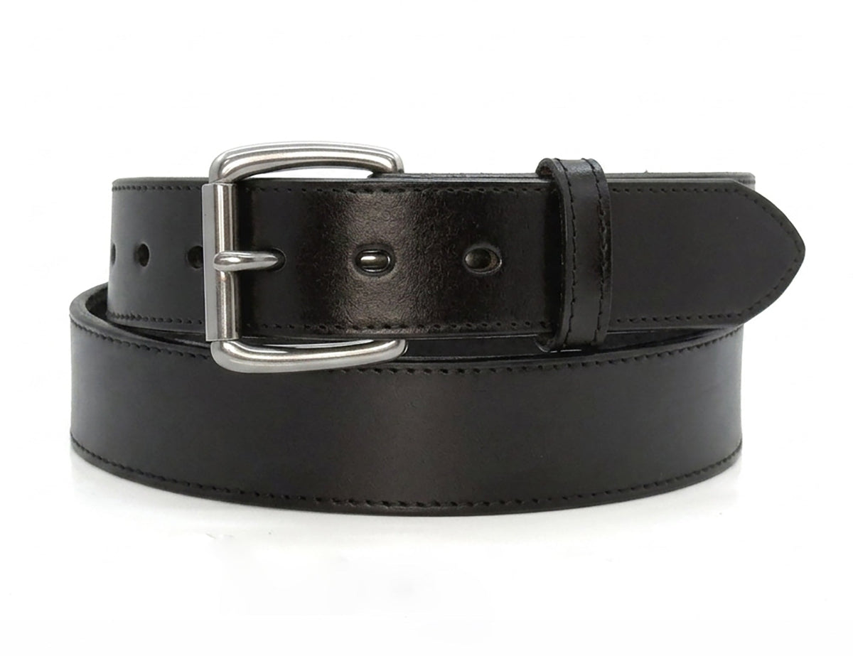 Black stitched-edge steer hide leather belt coiled on white, showing its silver-tone buckle, matching keeper, and pointed tip.