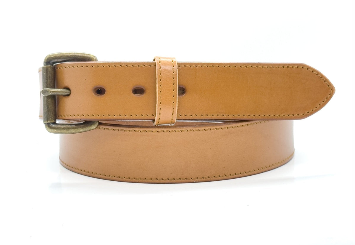 Tan full-grain steer hide leather belt with edge stitching and a brass-tone buckle on white.