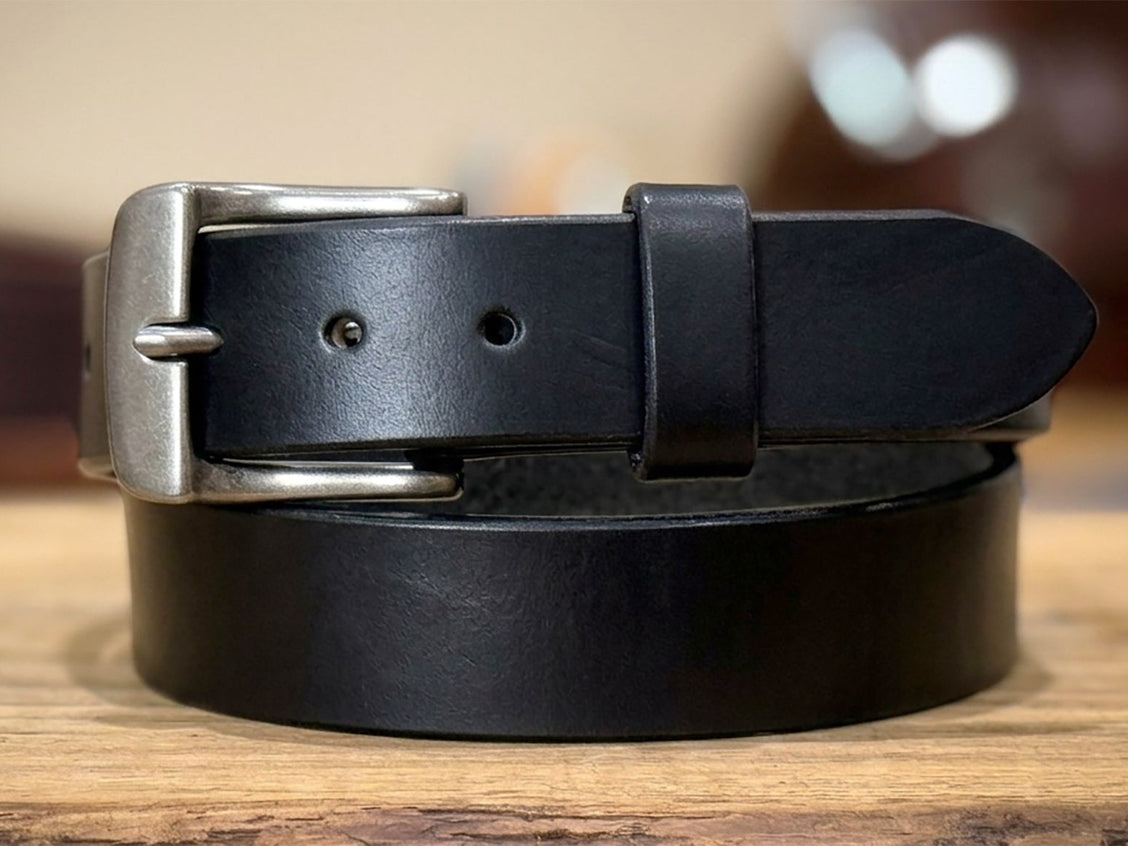 Black harness belt displayed upright to show buckle, keeper, and substantial leather.