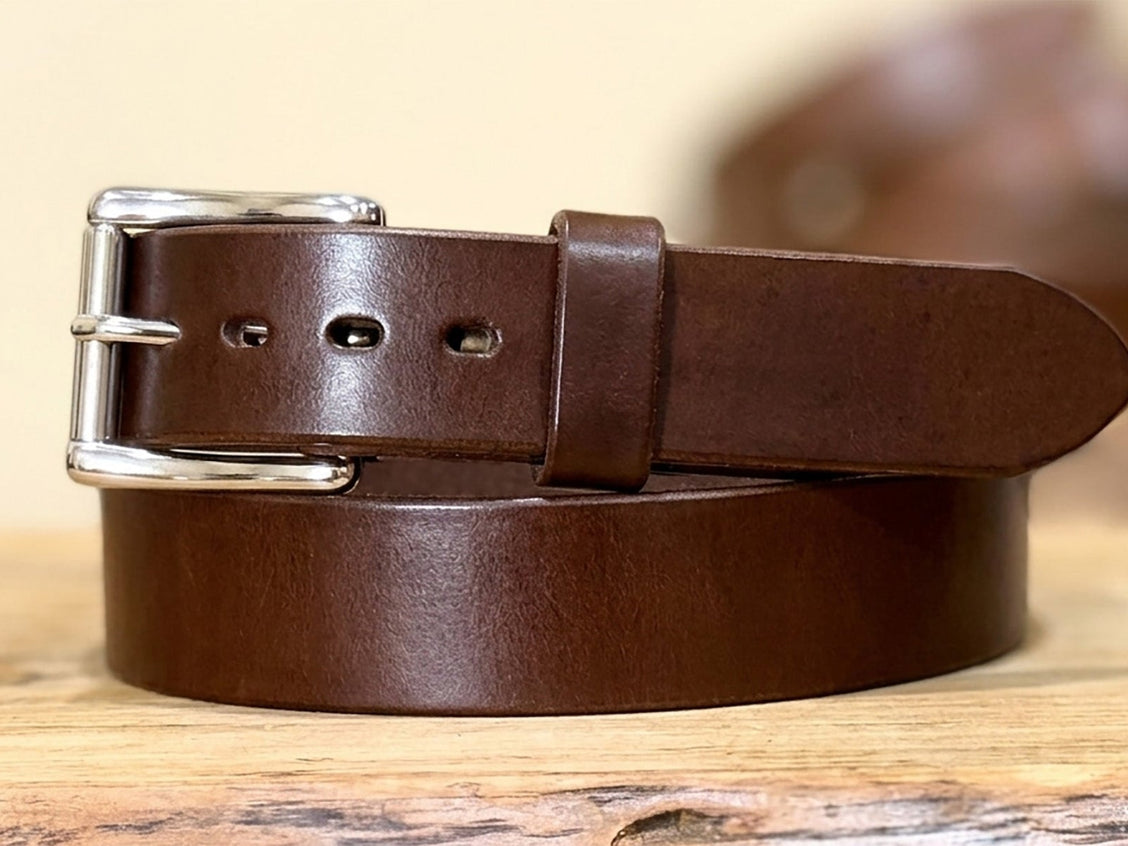 Brown harness leather belt detail showing the full-grain surface and finished edge