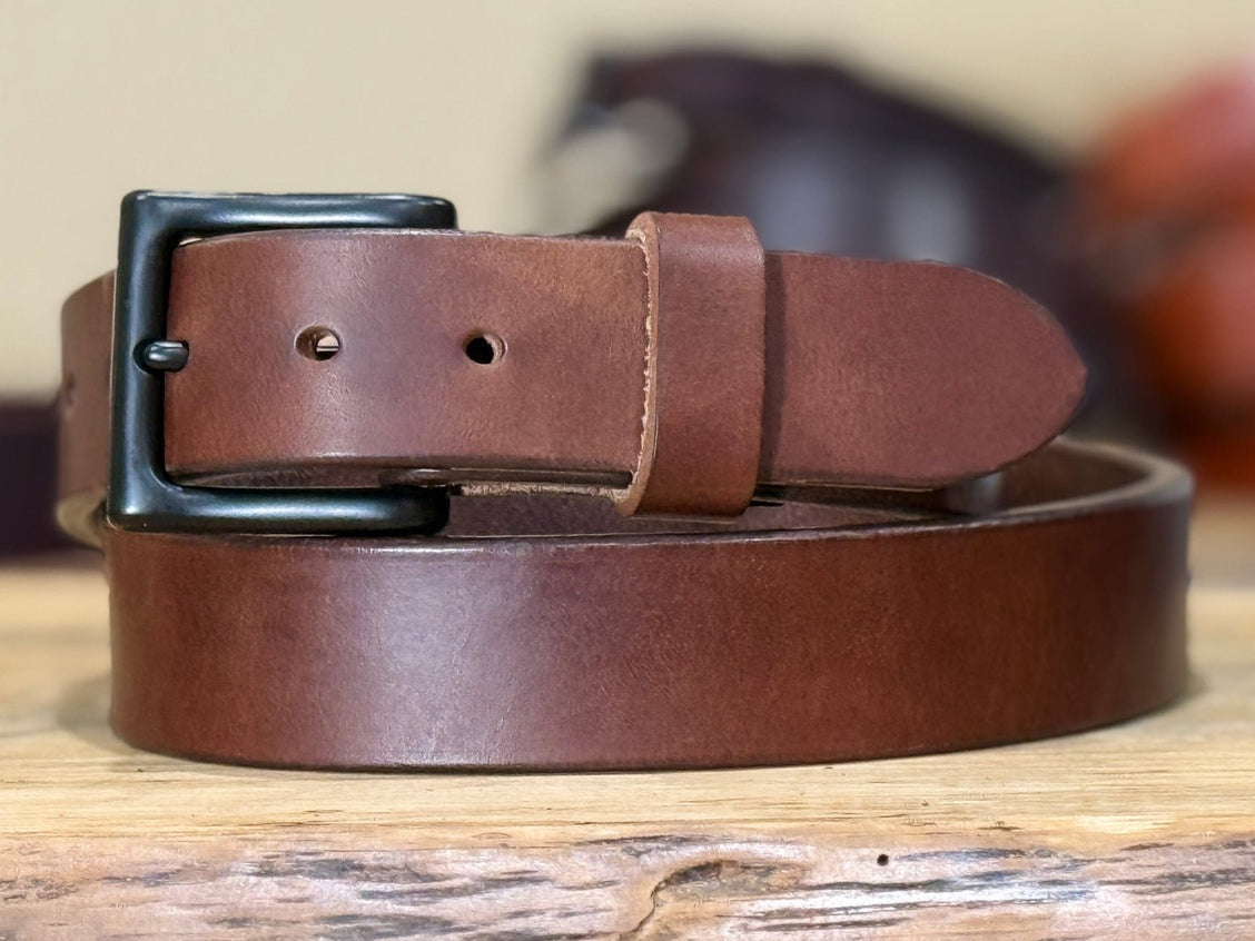 Brown harness belt displayed upright to show buckle, keeper, and substantial leather