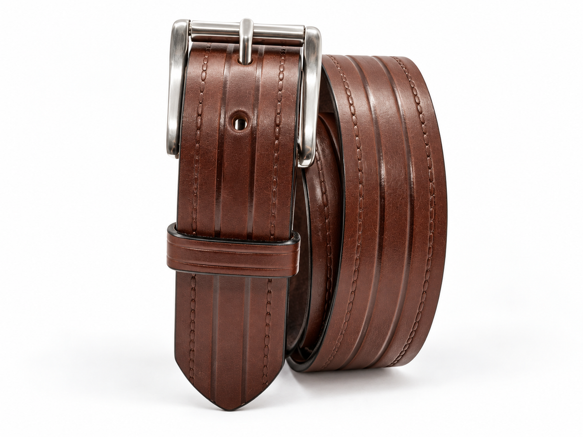 Brown Rancher heavy-duty full-grain leather belt coiled to show embossed lines, keeper, and silver roller buckle.