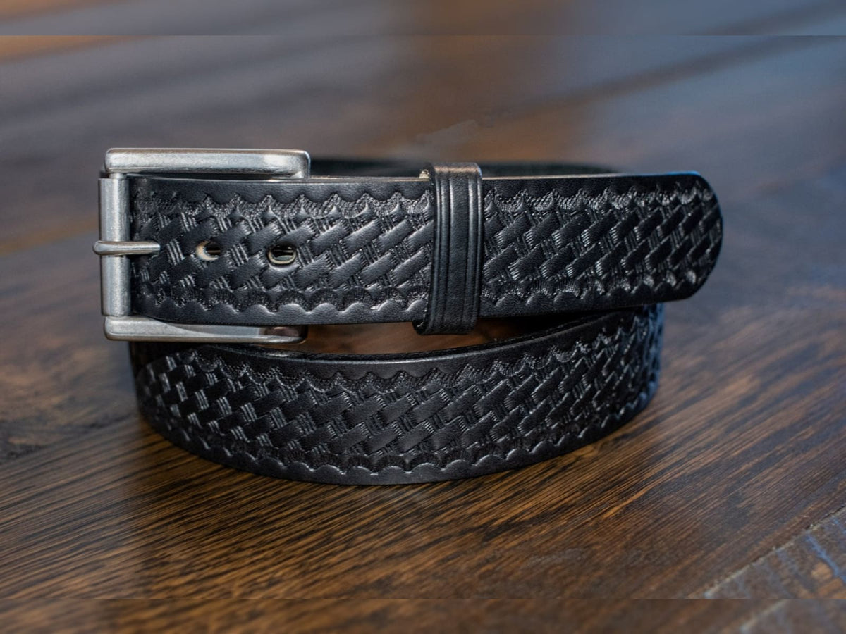 The Sheriff black 1.5 inch Amish made full grain Wickett & Craig harness leather basket weave belt with roller buckle on oak table.