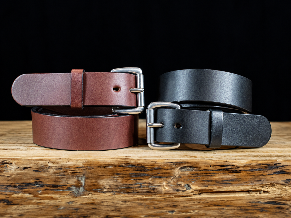 Black and brown Workhorse 1.5-inch full-grain leather belts coiled to show thick straps and silver roller buckles.