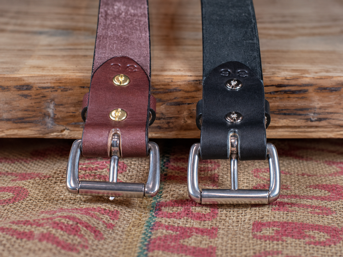 Back of black and brown Workhorse belts showing removable roller buckles secured with Chicago screws and leather keepers.